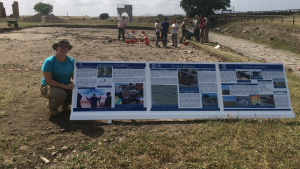 Katherine McCusker poses with the information panels she and created to inform visitors about the Vulci3000 project. 