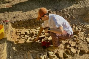 young woman excavating in an archaeological trench