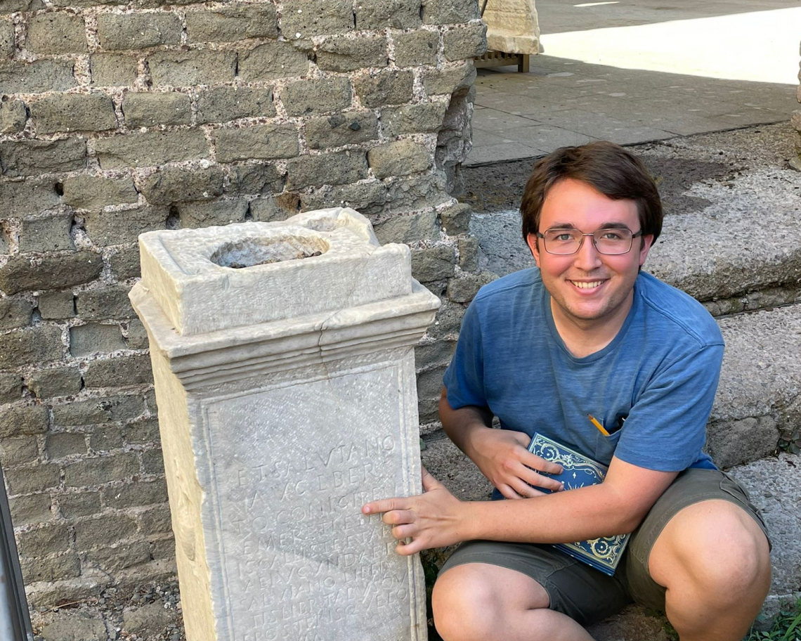 Ben highlighting a BEN (from BENE MERENTI) on an inscription at the tomb of Cecilia Metella.