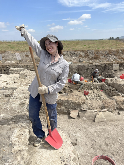 Posing with a shovel after cleaning a unit in preparation for excavation