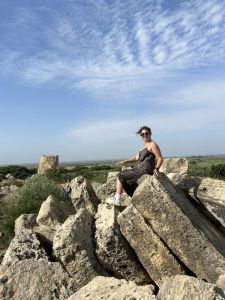 young woman sitting atop toppled ancient ruins