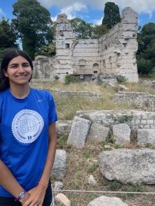 young south asian woman in front of ancient ruins